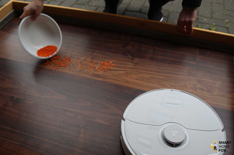 Различные виды грязи разложены на полу перед Roborock S8 Pro Ultra.